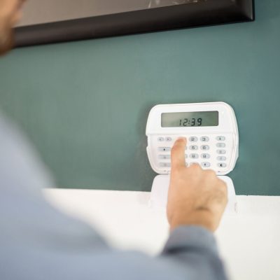 Arming a home alarm system Closeup of the hand of a man using a keypad to arm his home alarm system